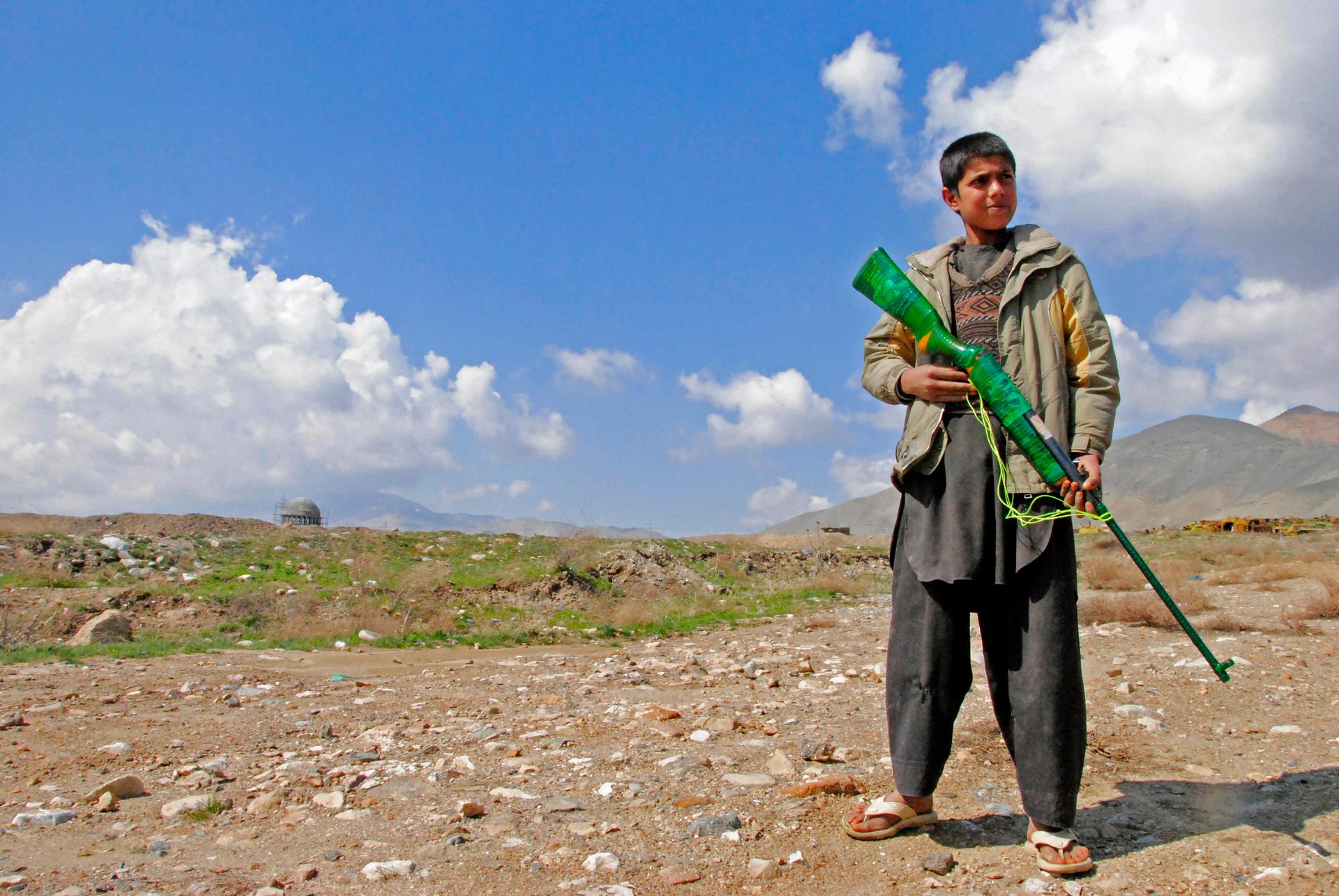 A young shepherd poses as a security guard with a toy gun on the outskirts of Kabul. The United Nations Special Representative to Afghanistan, Ján Kubiš, has stressed the need to prevent the recruitment of children as soldiers.