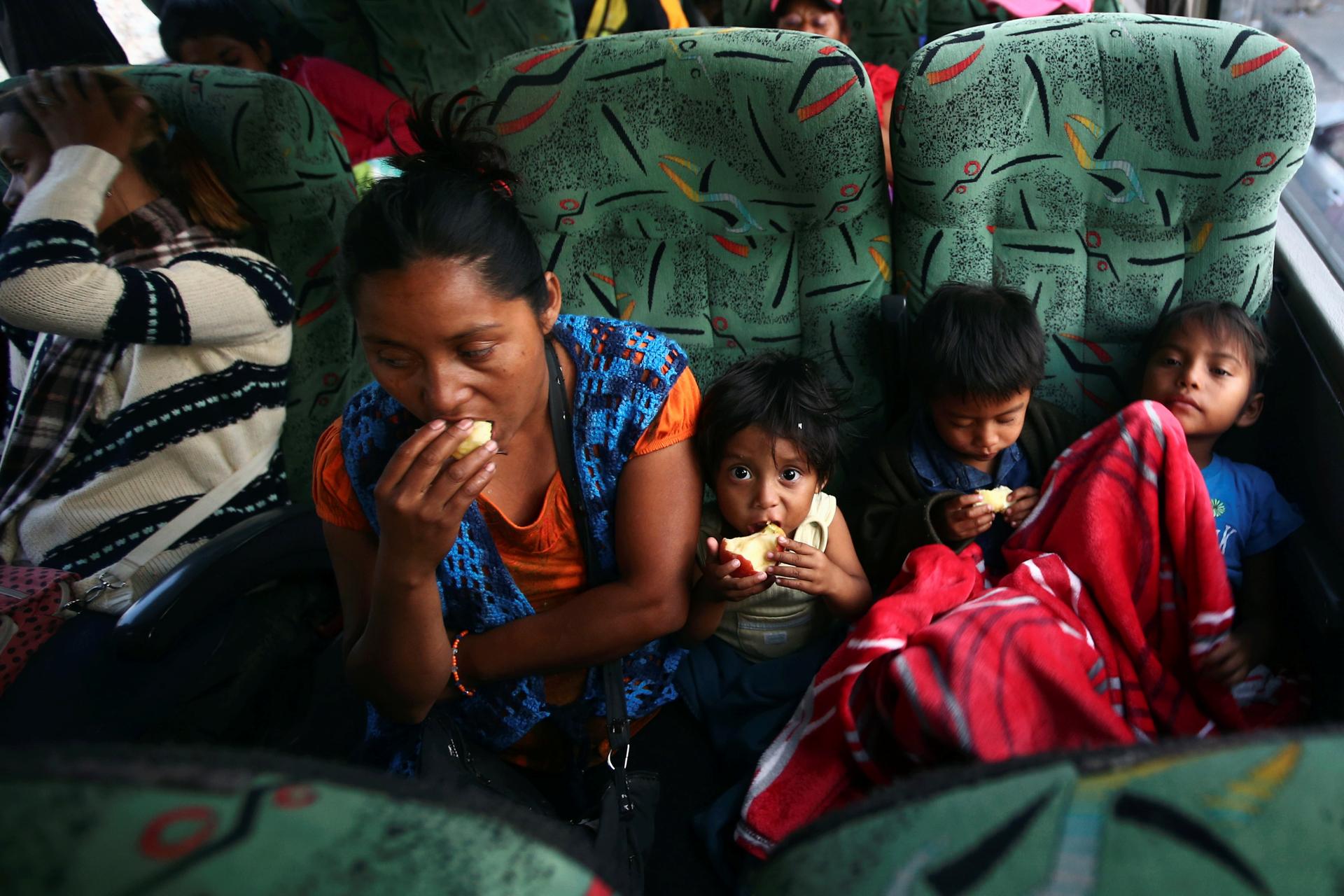 Central American migrants moving in a caravan on a bus through Mexico are seen eating.