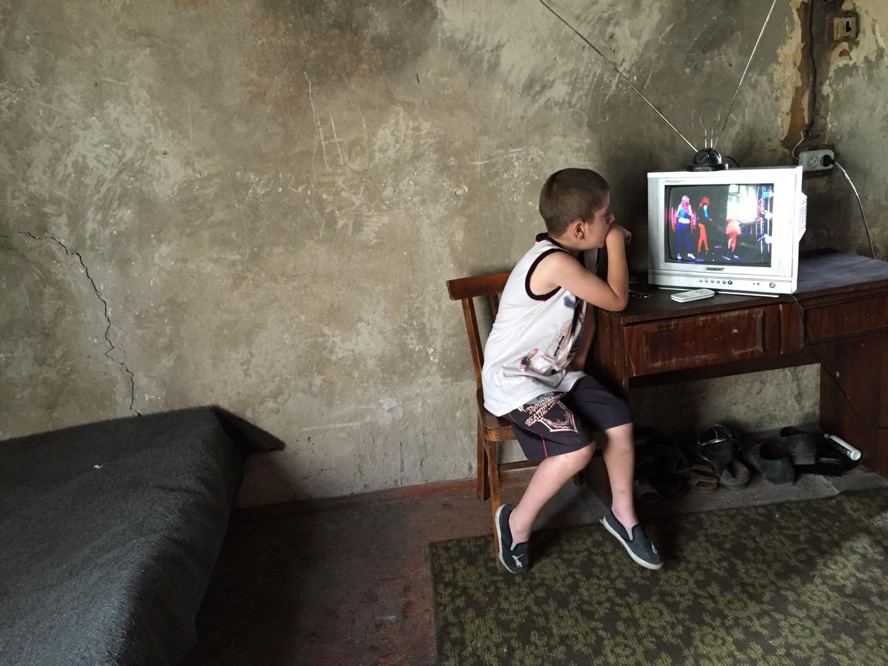 Ashot, 7, passes time in the domik where he lives with his mother and two sisters. They had been living and working in Russia but came back last year. The Shirak Centre has supported them with basic supplies.