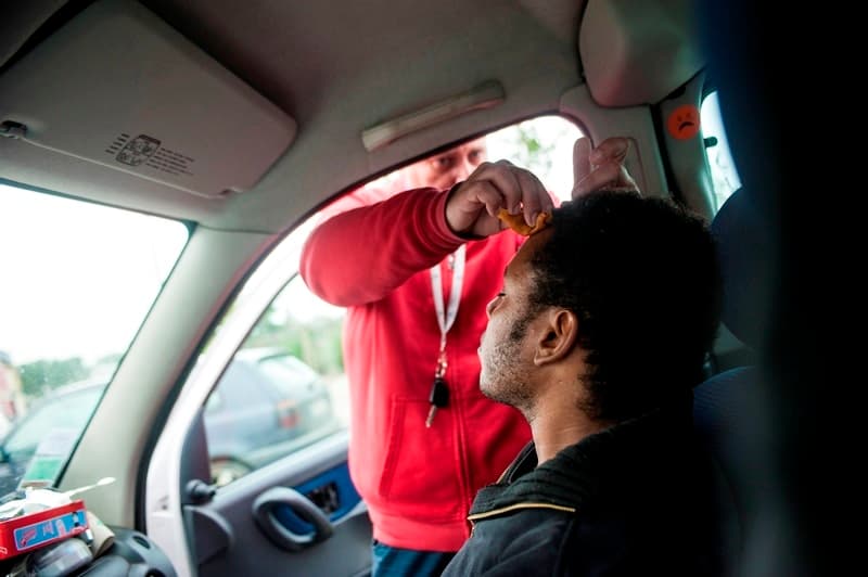 Mehdi D, a volunteer nurse with the group “Réveils Voyageurs,” treats Qeraso’s head wound, July 26, 2017.