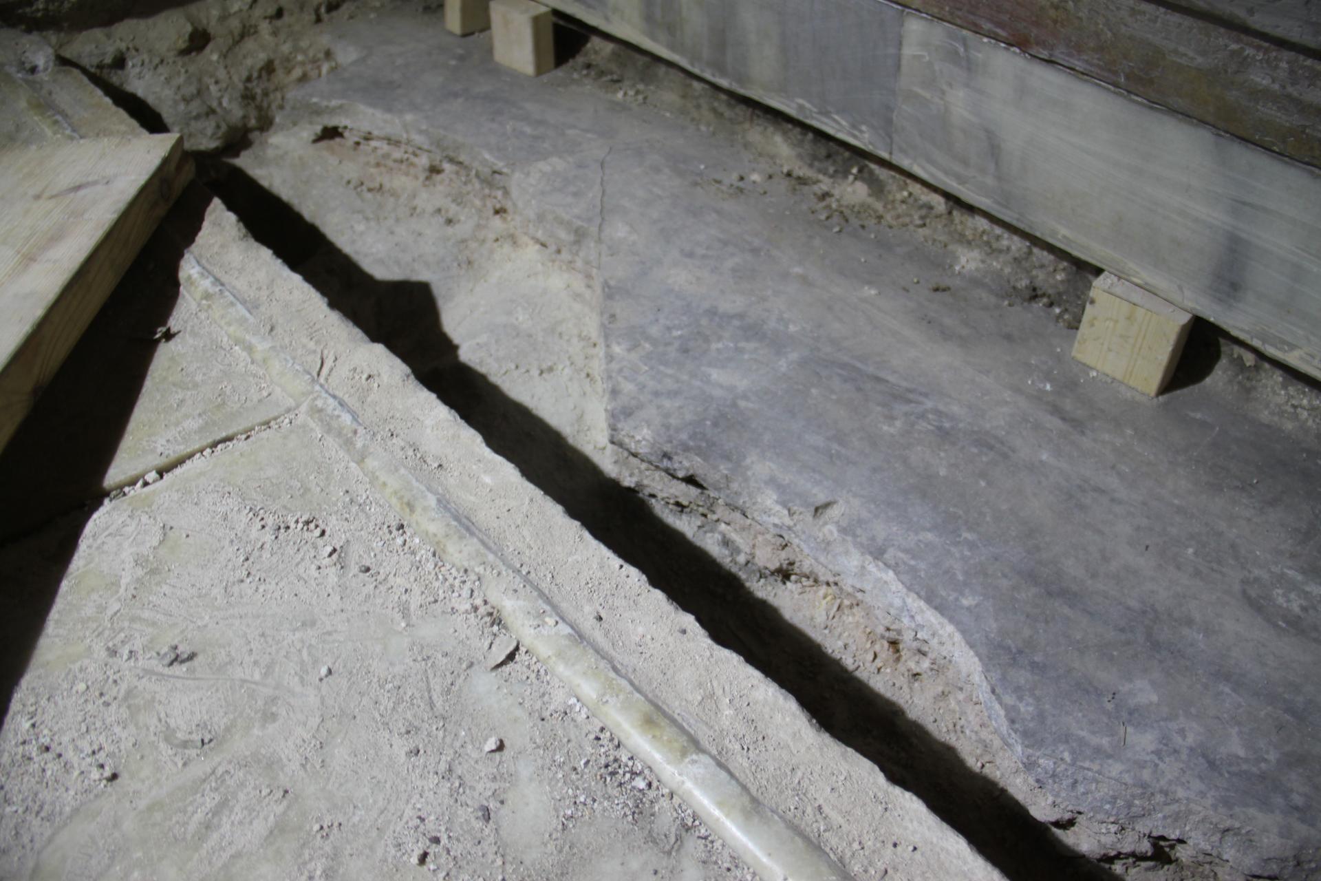 The marble lid (on the left) was pulled off, revealing a partly broken gray slab of marble. Under that is the debris-covered limestone layer where Jesus; body was said to have been placed after he was crucified.