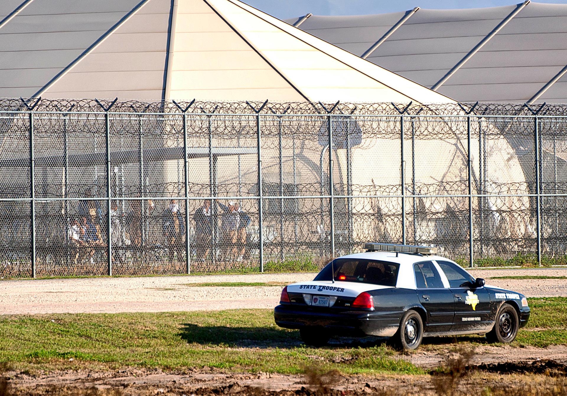police cars in front barbed wire, where prisoners look out
