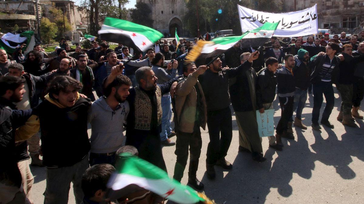 People attend an anti government protest in Bab al-Hadid district of Aleppo, March 4, 2016. The text on the banner reads in Arabic, 