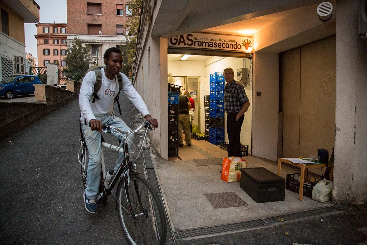 Barikama co-founder Seydou Baldeh from Gambia delivers yogurt on a bike to an ethical buyers group in Rome.  They keep the yogurt cool in black styrofoam boxes that empty out fast.