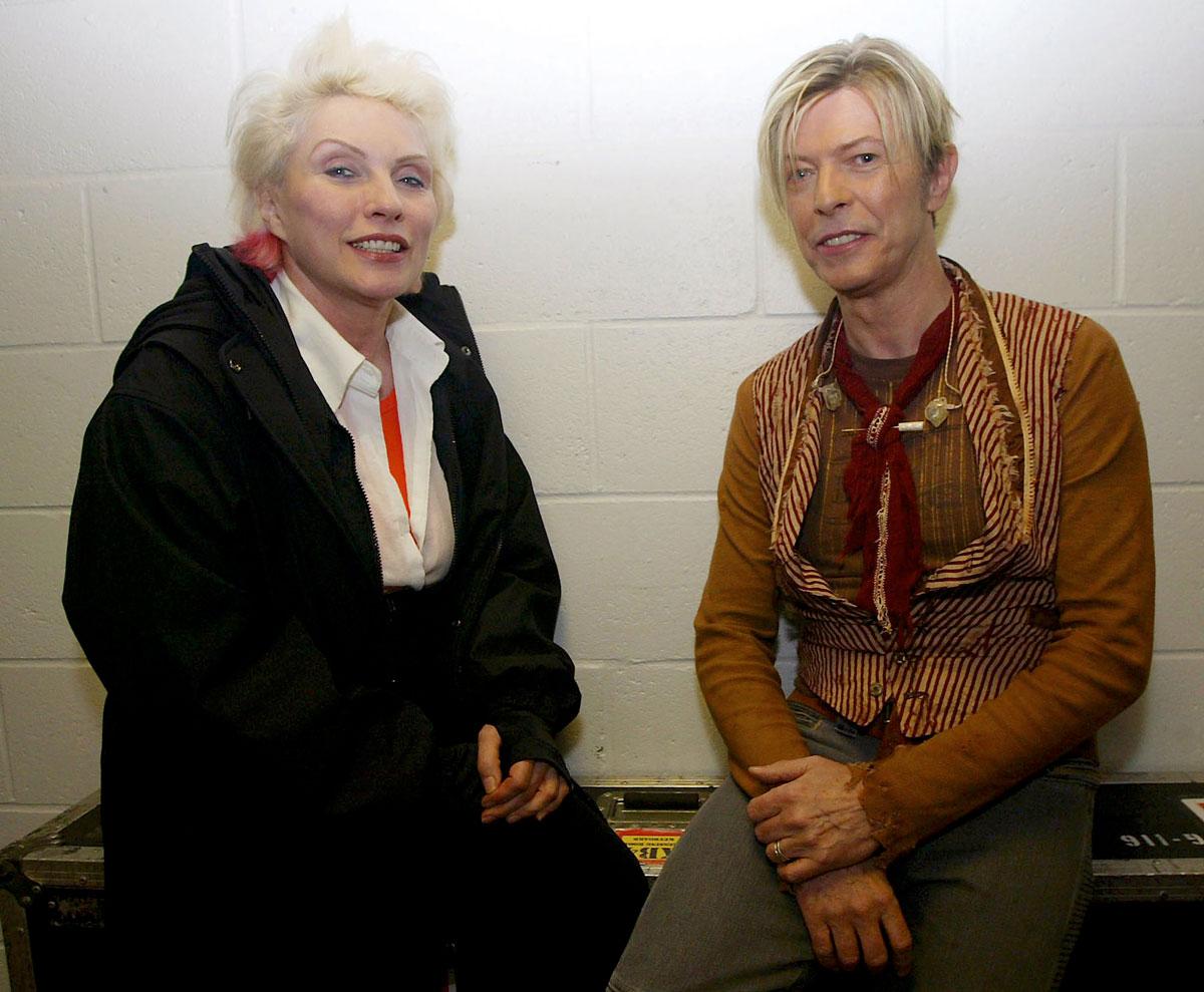 David Bowie sits with Deborah Harry, the lead singer of the band Blondie, before the first concert of his UK tour in Manchester, November 17, 2003.