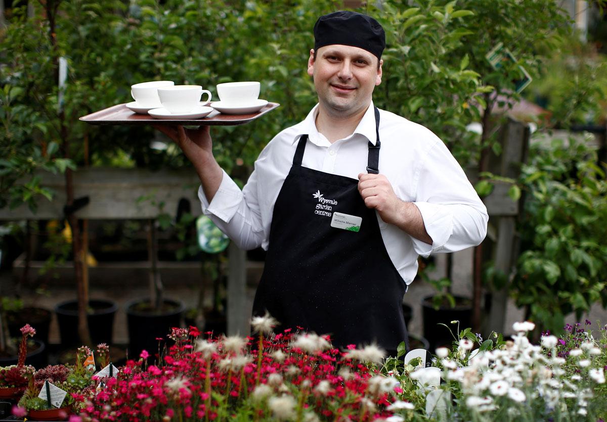 Mihai Marcar, a Romanian waiter at a garden center restaurant, poses for a photograph in Addlestone, Britain.