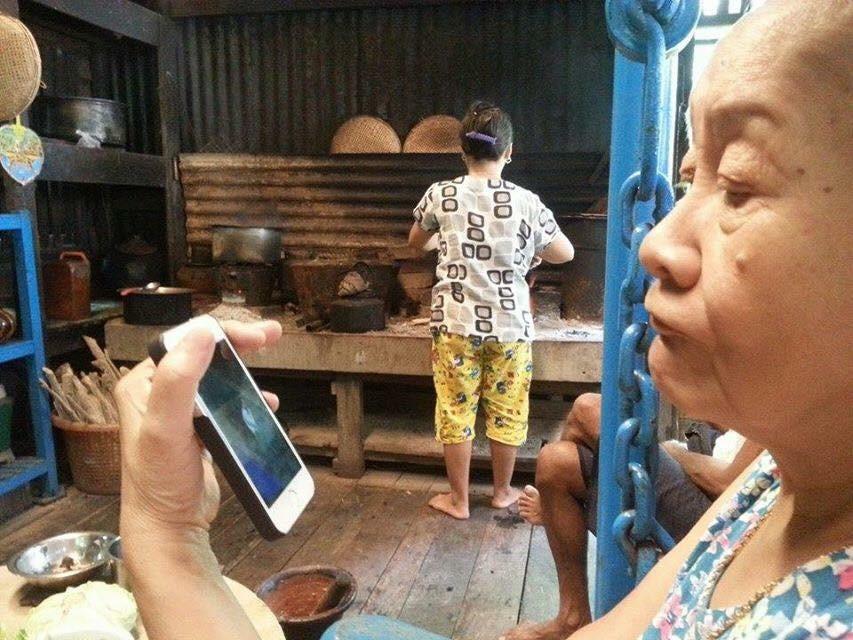 Burmese woman tries out her new cell phone