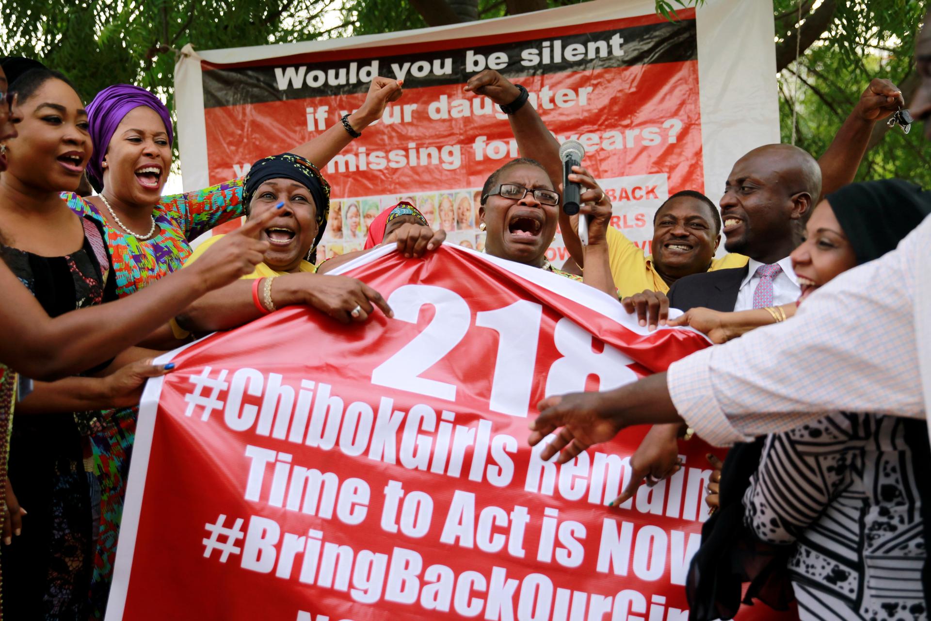 Members of the #BringBackOurGirls (#BBOG) campaign react on the presentation of a banner which shows 