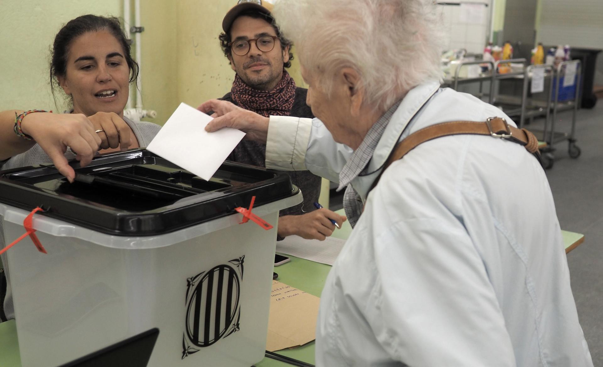 A voter partakes in a risky endeavor: casting a ballot in Catalonia's outlawed referendum for independence from Spain.