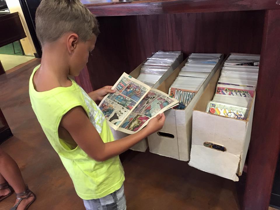 A child peruses comic books at Chicano-Con