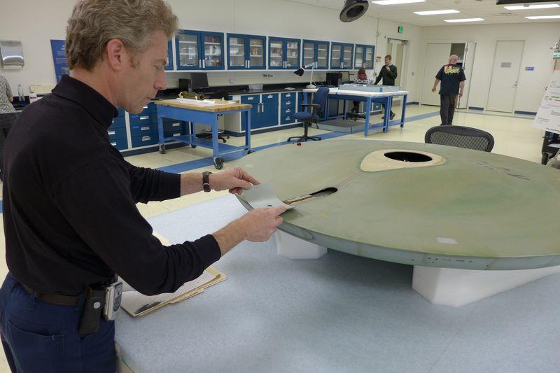 Museum Specialist David Wilson finds the exact color match to the grey paint inside the saucer.