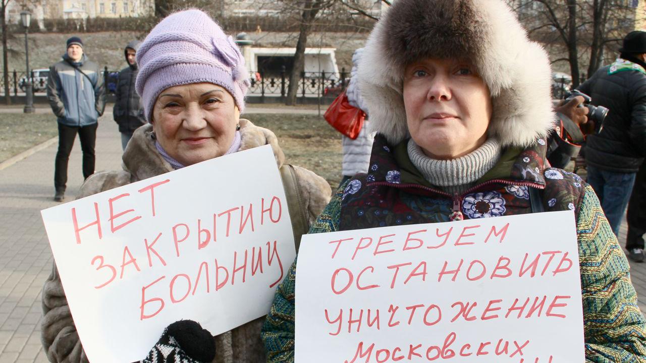 Two women in Moscow protesting sweeping health care reforms. Their signs read 