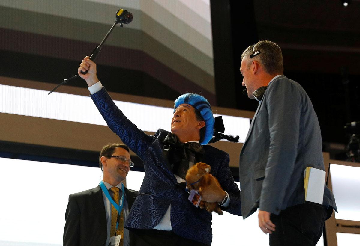 Television host Stephen Colbert tries to take a selfie as he is escorted off the stage before the DNC.