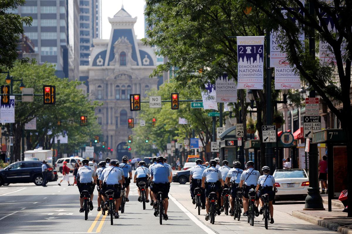 Police ride bicycles down Market Street toward City Hall ahead of the DNC.