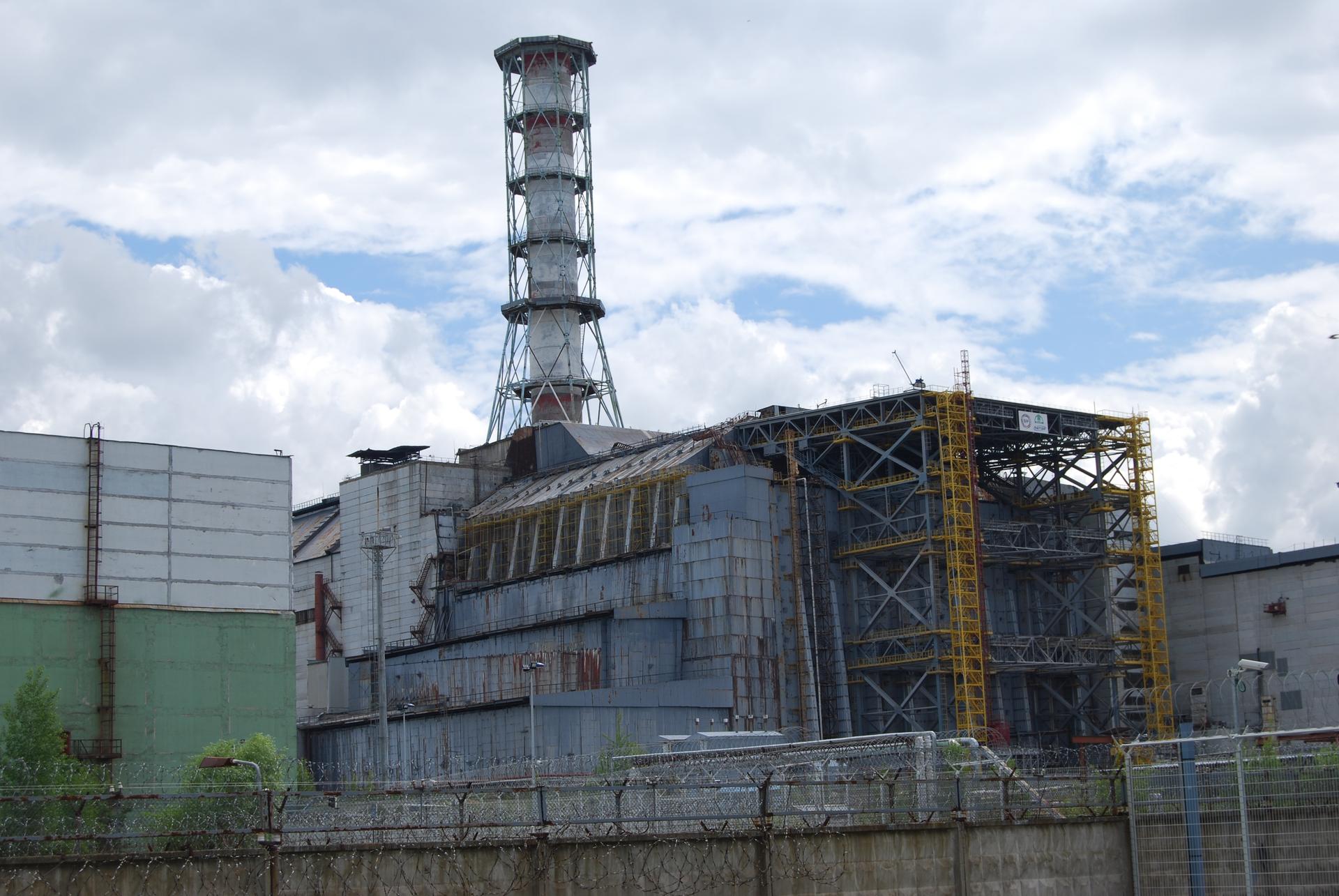 The sarcophagus, a massive steel and concrete structure, covers nuclear reactor 4 at the Chernobyl Nuclear Power Plant. The shell was designed to limit further radioactive contamination.