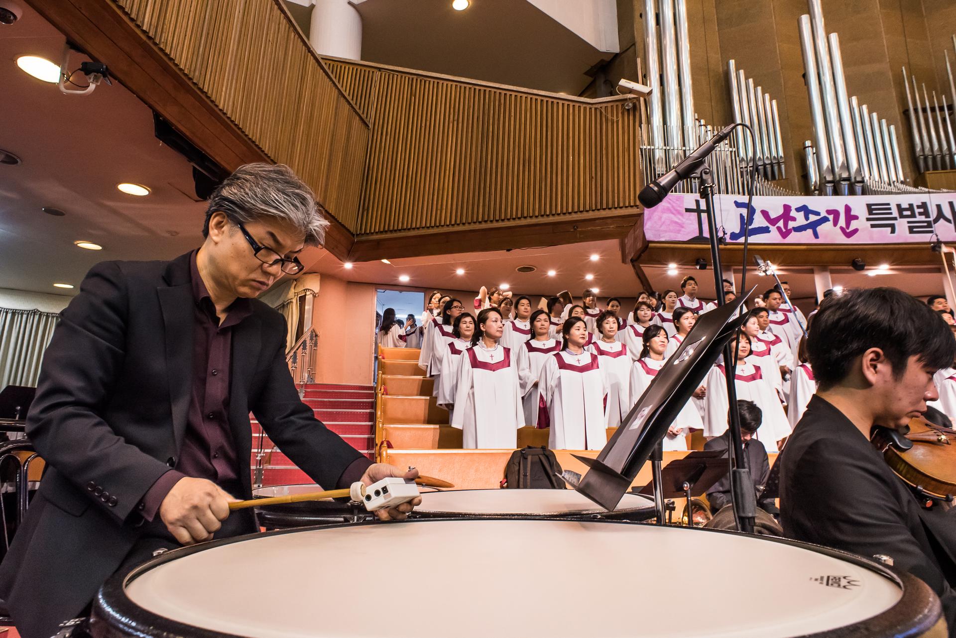 The message at Yoido Full Gospel Church is about faith, the Bible, and prosperity. The music is provided by a professional choir and a full orchestra.
