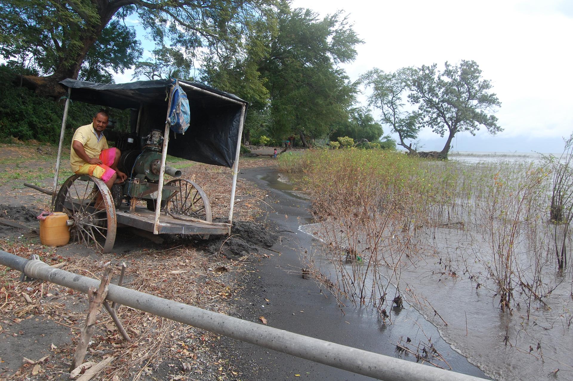 Ometepe farmer Dayton Guzman fixes his irrigation pump on the shore of Lake Nicaragua. Surveyors recently showed up on his farm representing a company that wants to build a hotel related to the canal project. Guzman says he and his family don't want to se