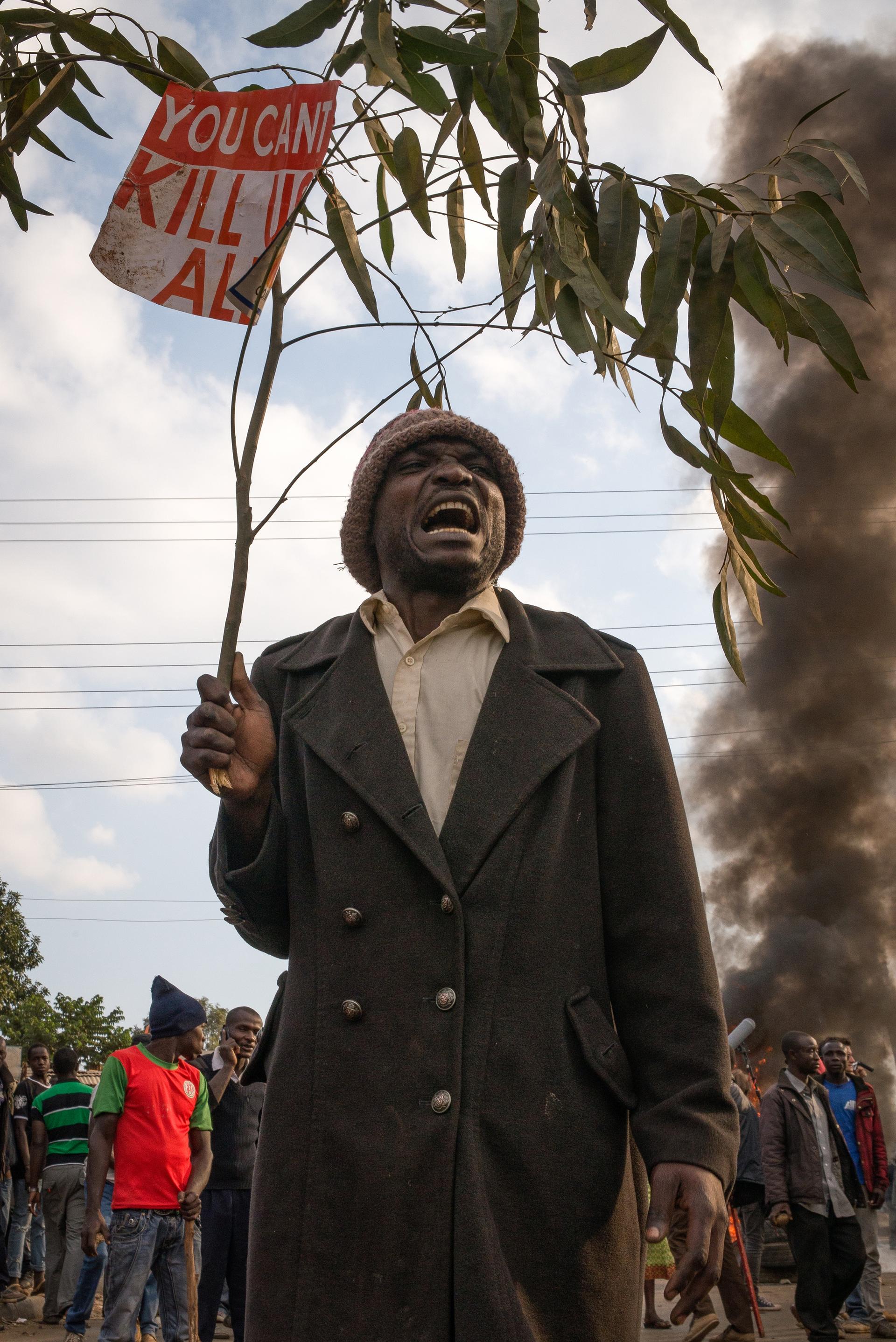 A man holds a sign that reads “you can’t kill us all” during a protest in an informal settlement in Nairobi, Kenya. Protesters were demanding that current President Uhuru Kenyatta concede to presidential candidate Raila Odinga of the opposition party.