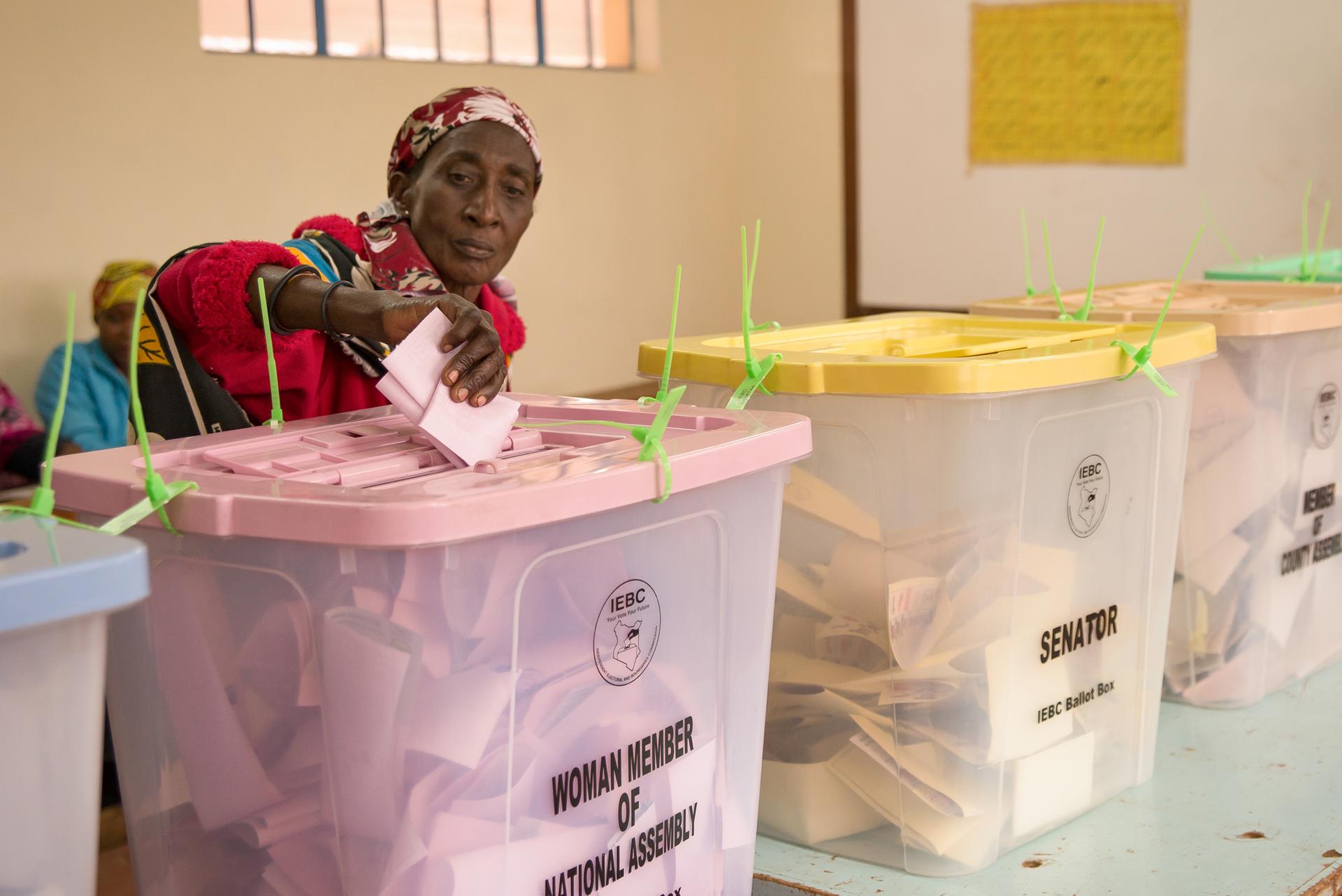 An elderly woman submits her ballot at Kibera Primary School in Nairobi. Many voters withstood long lines and slow registration technology to vote in Tuesday’s elections.