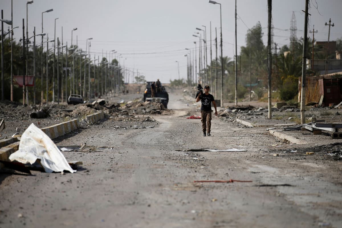 A member of Iraqi counterterrorism forces walks with his weapon in Fallujah.