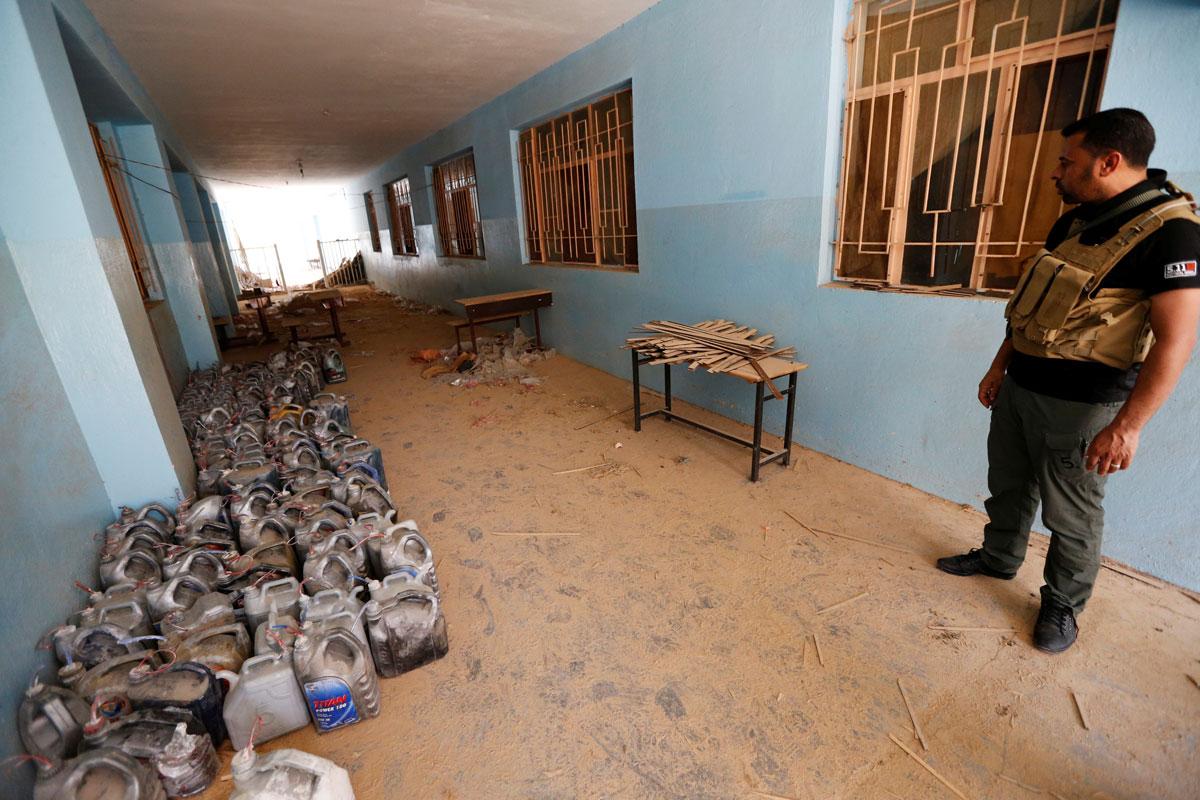 A member of the Iraqi security forces looks at explosives abandoned by Islamic State militants at a school in Fallujah.