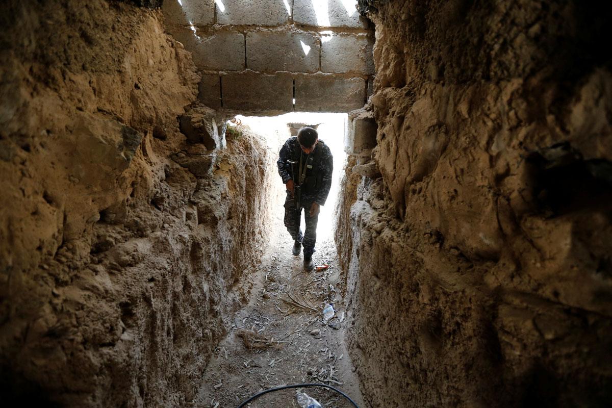 A fighter from the Iraqi Shiite Badr Organization holds his rifle in an underground tunnel built by ISIS fighters on the outskirts of Fallujah.