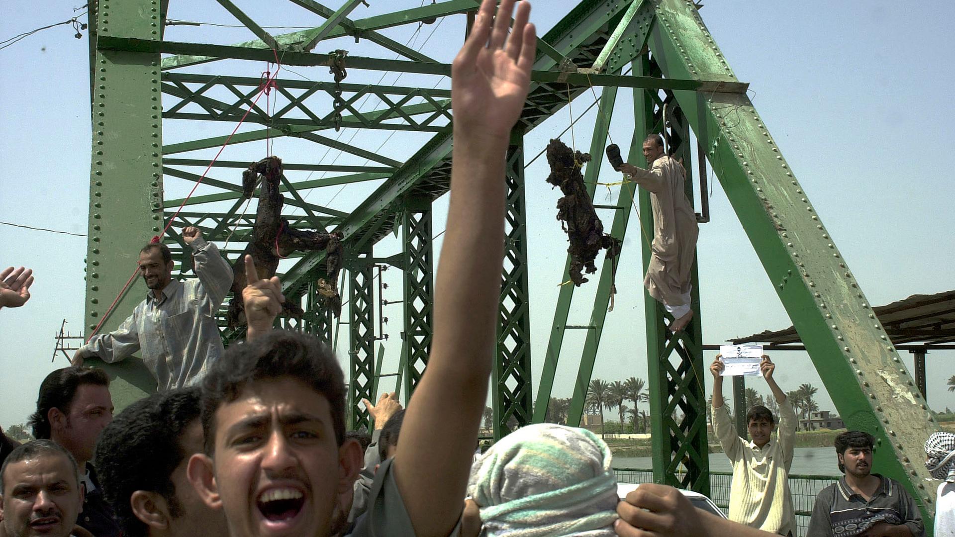 Iraqis chant anti-American slogans as charred bodies hang from a bridge over the Euphrates River in Fallujah, west of Baghdad, in 2004.