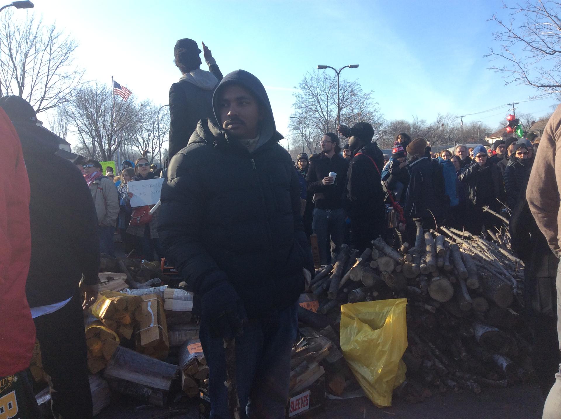 Jayson Morris stacks firewood for protestors