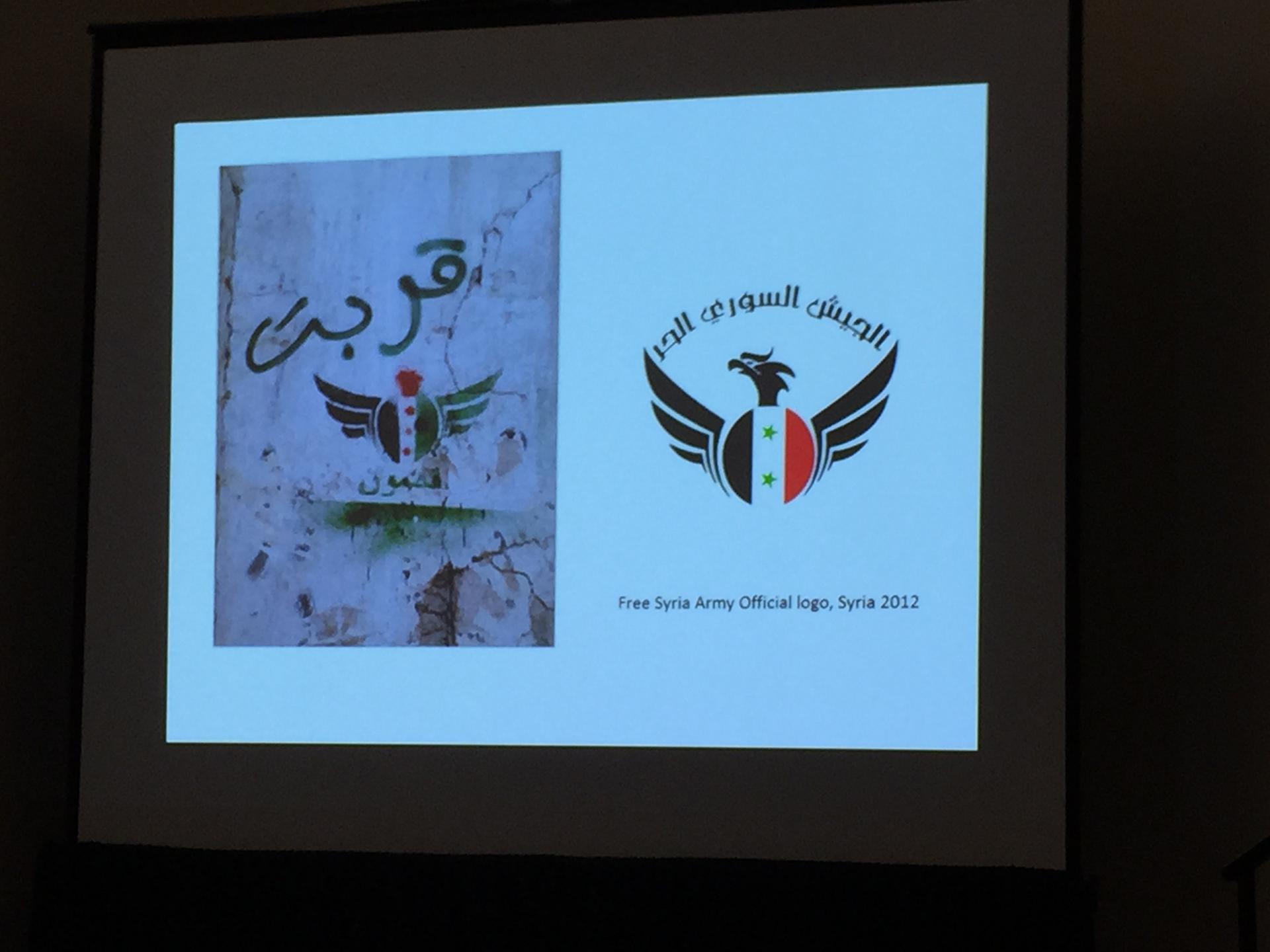 Picture of the presention taken during Elliott Goat's SXSW talk showing the Free Syria Army's designed logo.
