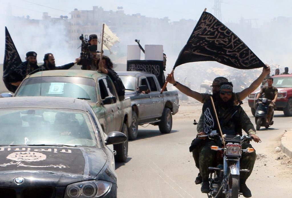 Fighters from Al Qaeda's Syrian affiliate Al-Nusra Front in the northern Syrian city of Aleppo flying Islamist flags as they head to a frontline on May 26, 2015.