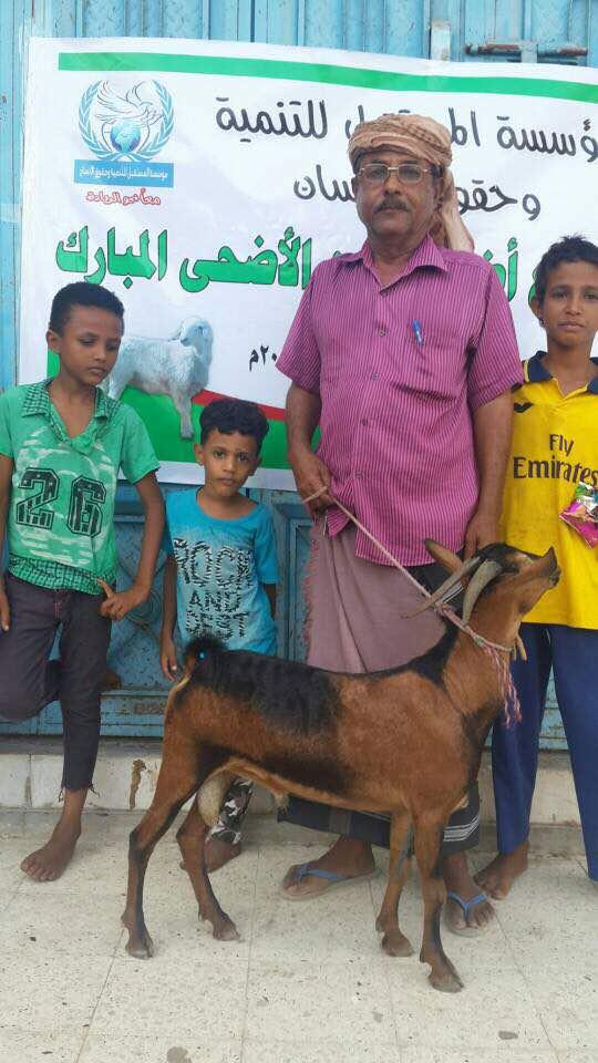 A man in Aden, Yemen, holds tight to the leash of a goat.