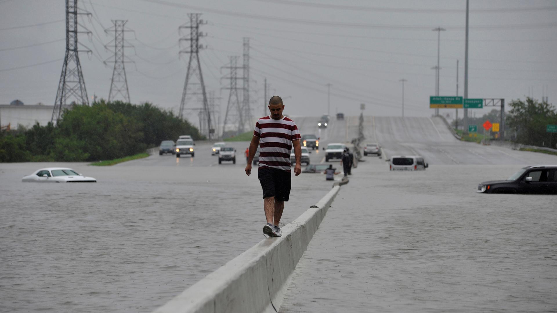 A stranded motorist escapes floodwaters on Interstate 225 after Hurricane Harvey inundated the Texas Gulf coast with rain causing mass flooding in Houston.