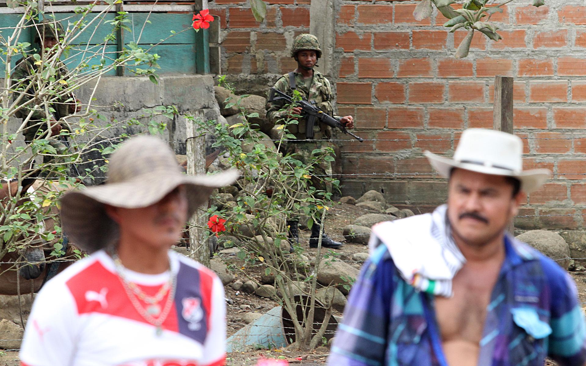Soldier looks on as San José de Apartadó Peace Community members commemorate 19 years of peaceful resistance.
