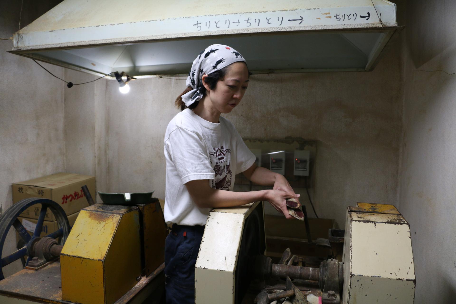 Akiko Kawanami shaves katsuobushi flakes in her family's shop. She grew up in the building above it.