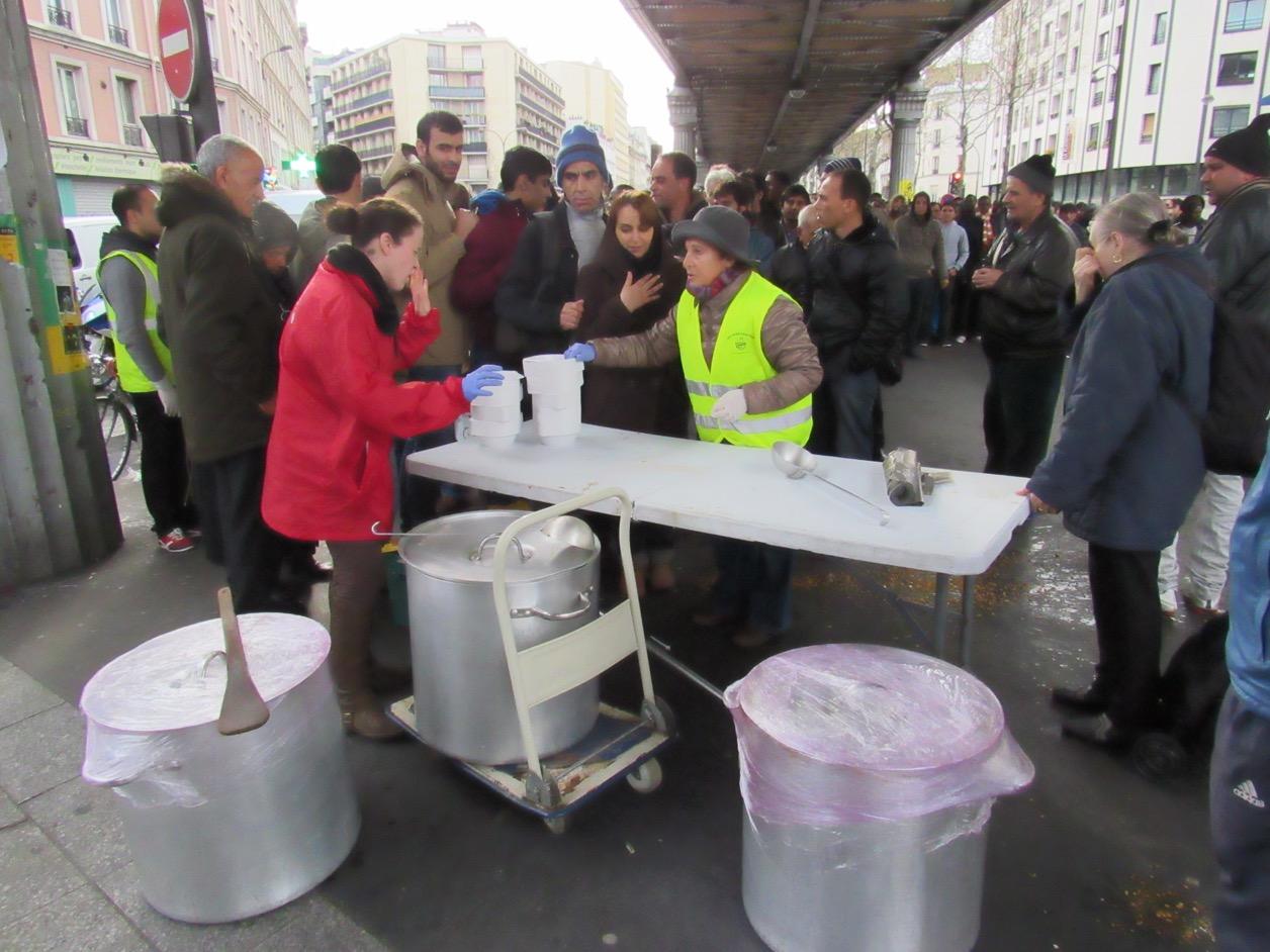 Volunteers help feed the many migrants who turn up to Paris' Stalingrad camp each day.