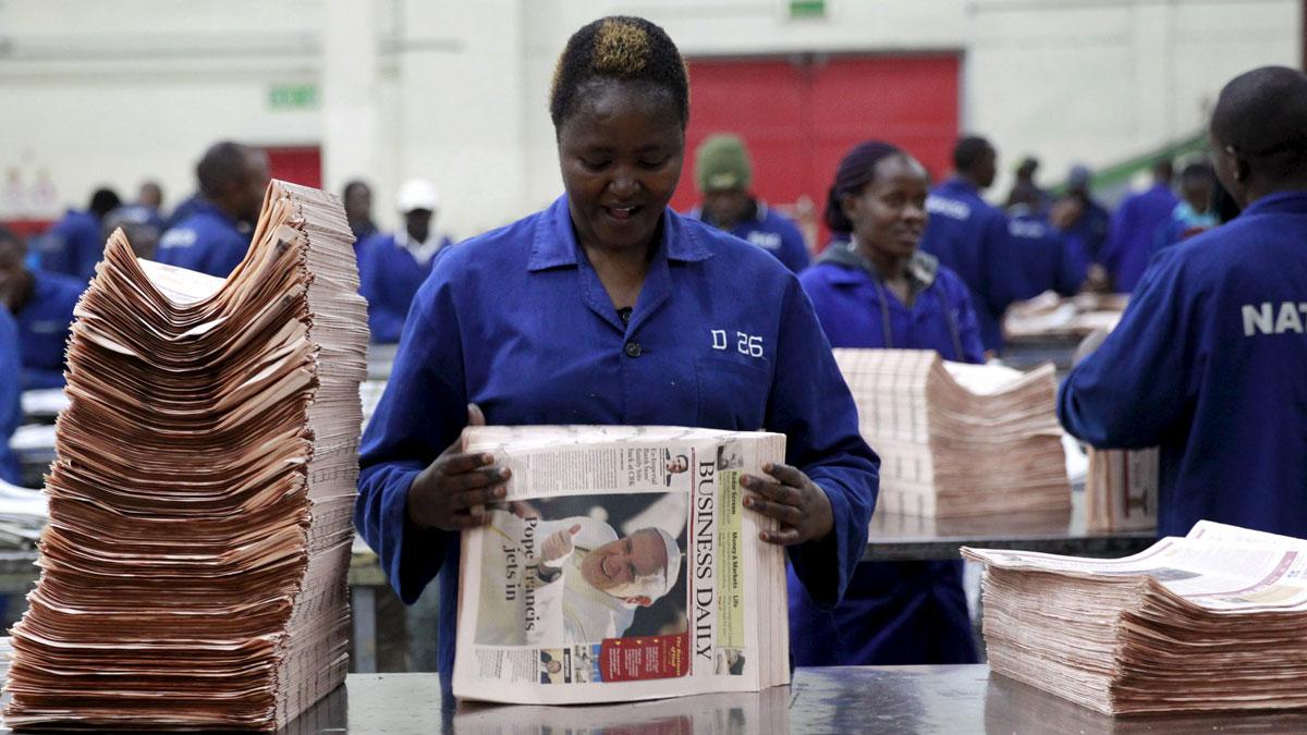 A worker arranges a copy of the Business Daily newspaper at a printing press plant on the outskirts of Nairobi.
