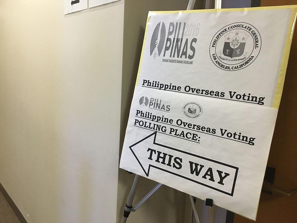 A sign with a big arrow to the Philippine polling place
