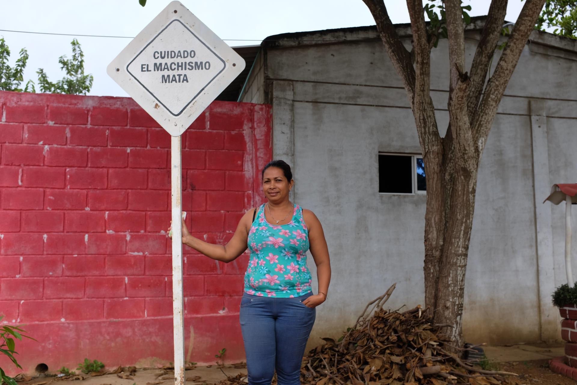 Eidanis Lamadrid stands next to a sign in the City of Women. 