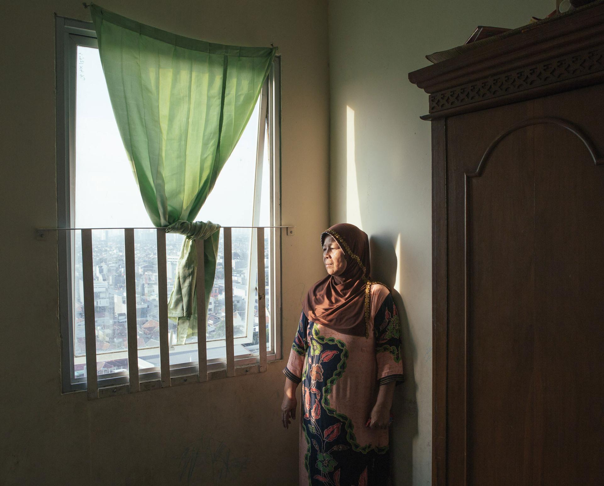 Former riverbank resident Syafitriani now lives in a subsidized apartment after being evicted from her home to make way for flod control projects. She says she lost most of her livelihood in the move and is having trouble paying the rent.