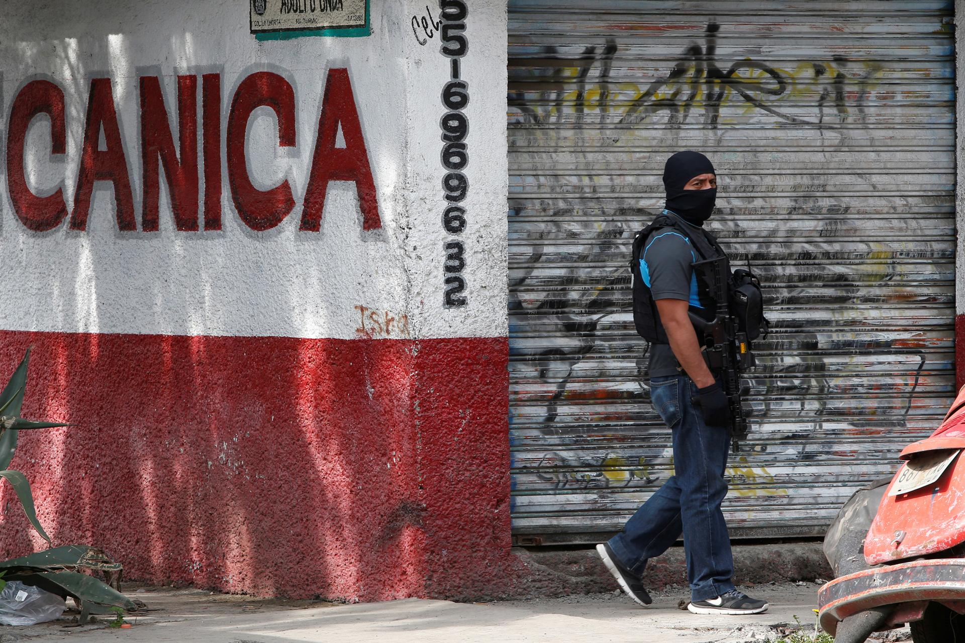 A Mexican police special agent guards an area after a shootout between gang members and the Mexican army in Mexico City.