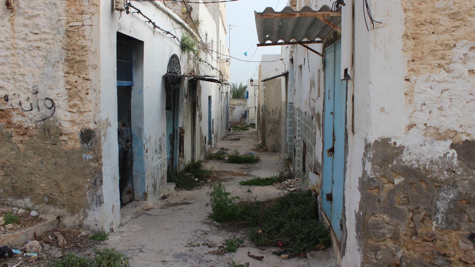In Sousse’s old town, the former red light district stands derelict and abandoned. Patches of wild grass have lodged in the midst of trash and rubble. “Go away,” reads the graffiti in Arabic painted on the walls.