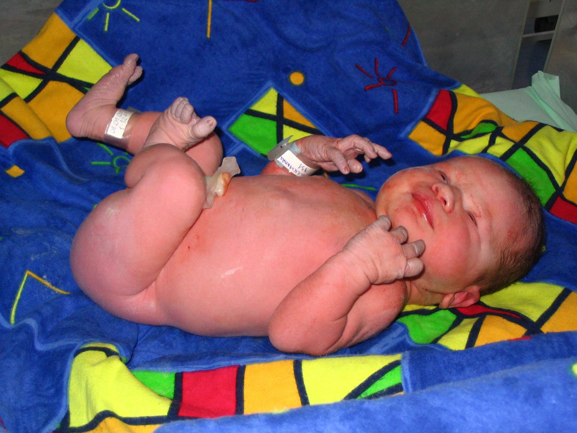 A newborn baby rests on a blanket just a few hours after being born.