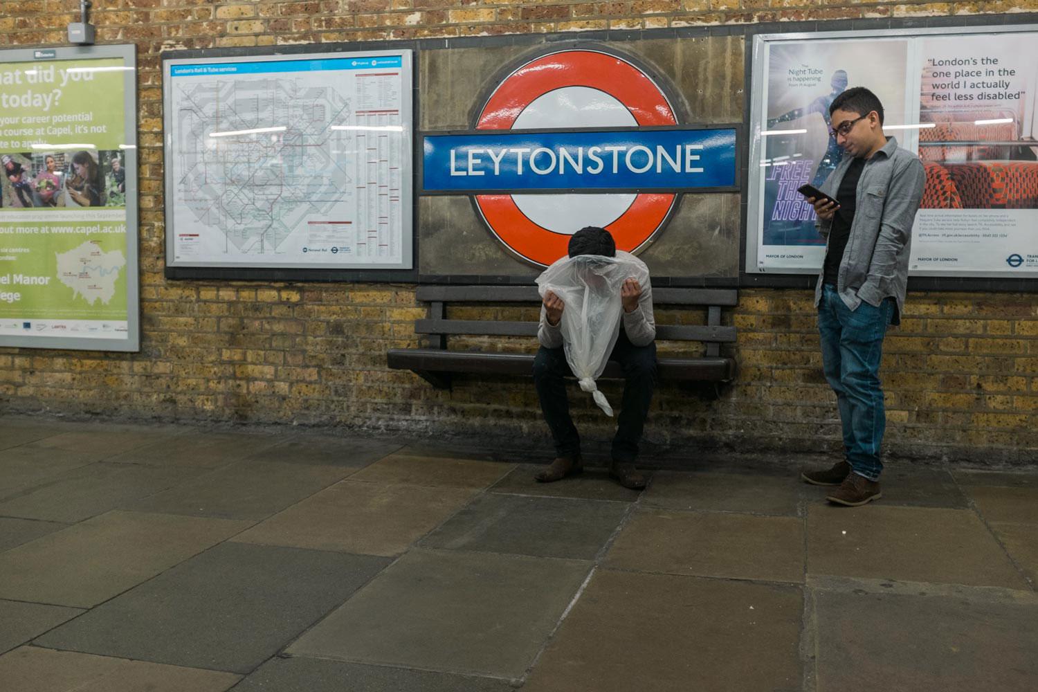 Only 36 minutes into the first ever night service on the Central Line and some revellers were finding it all too exciting. In this image a man gazes at his phone while his friend is sick into a garbage liner pinched from the platform.