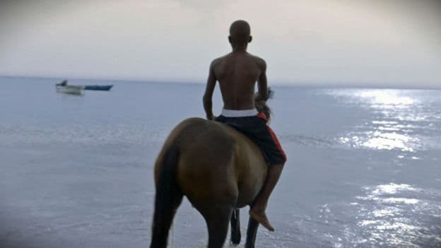 A man rides a horse on Old Providence.