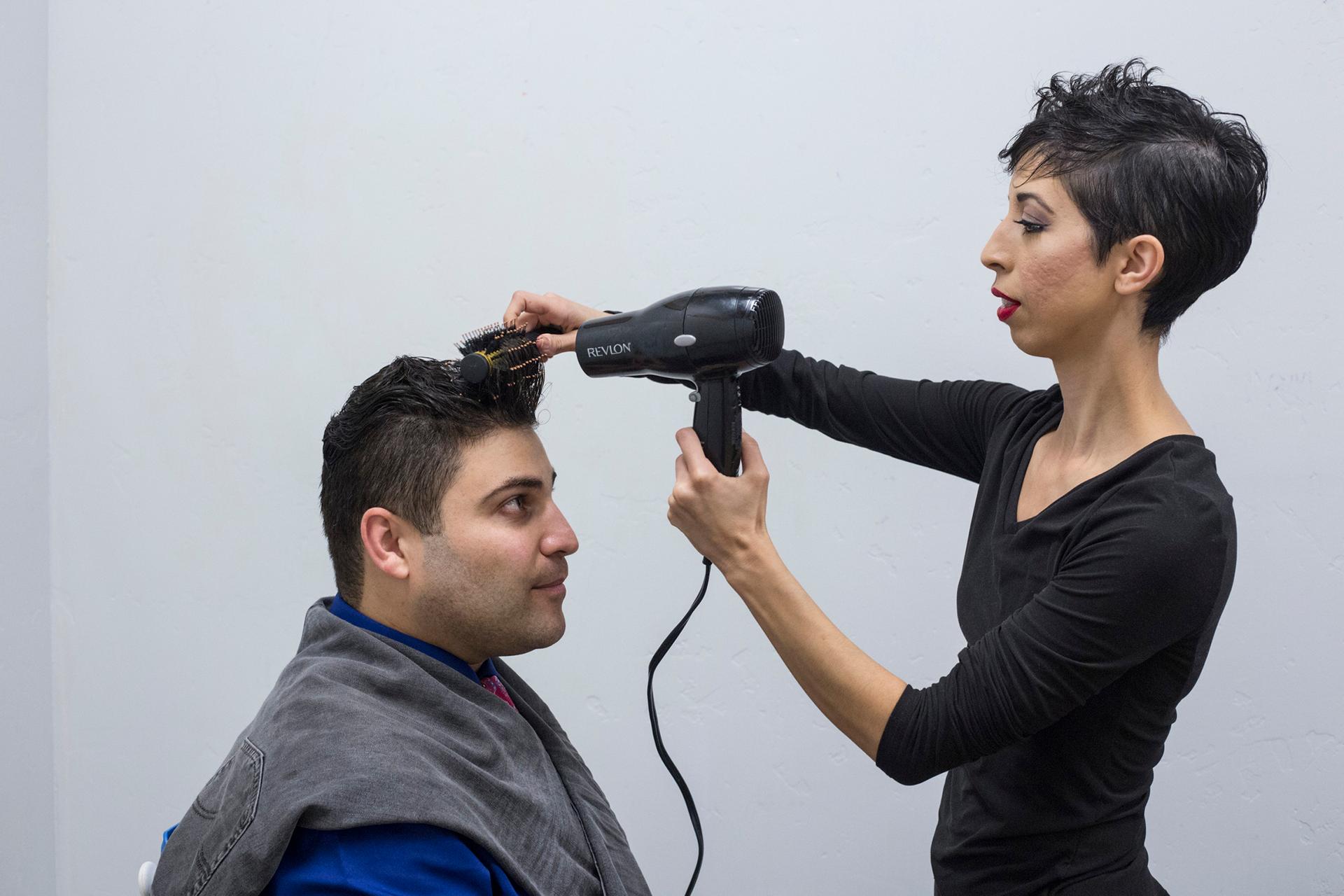 Omar’s wife, Jasmín, helps him fix his hair before their performance