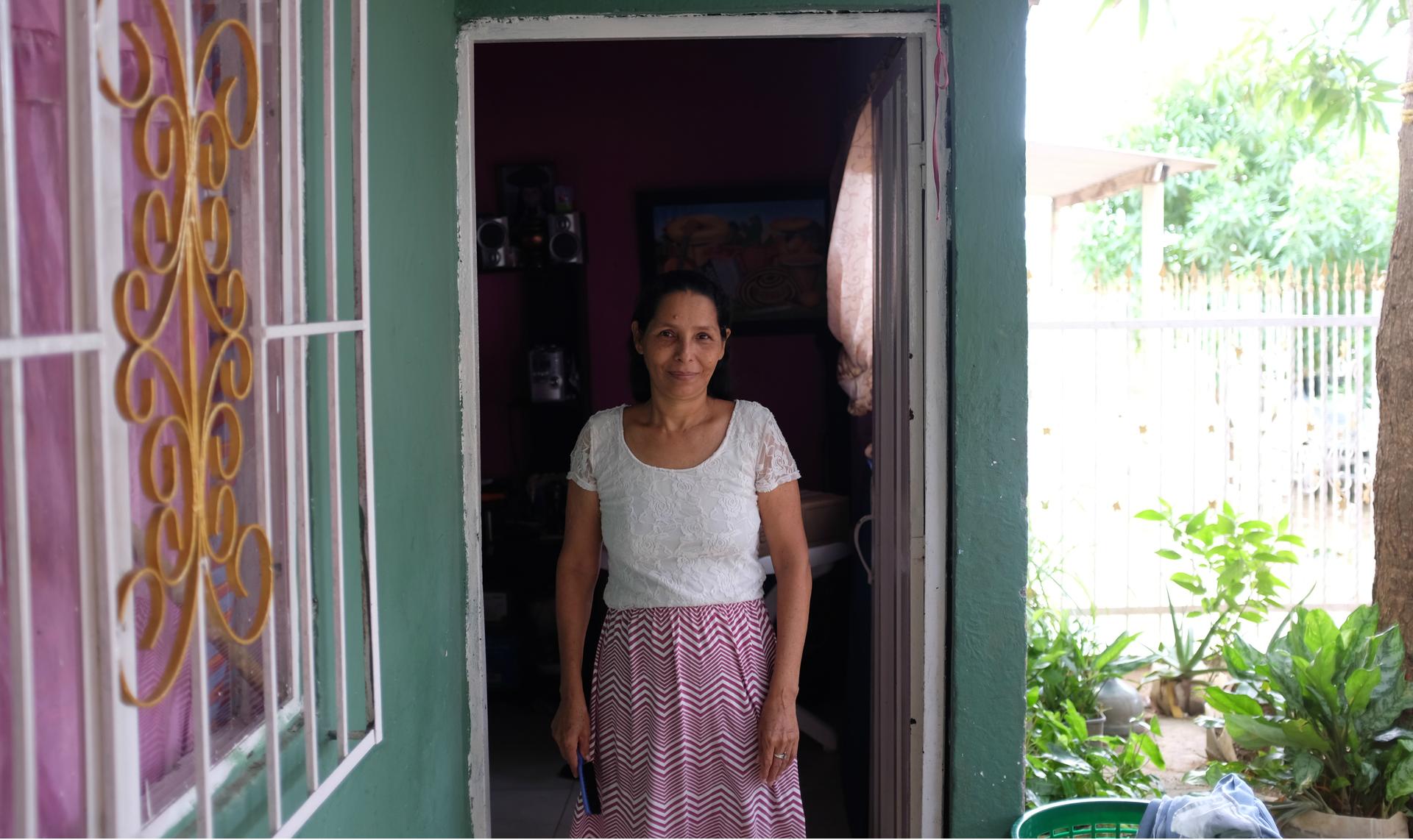 Ana Luz Ortega stands in the doorway of her home in the City of Women.