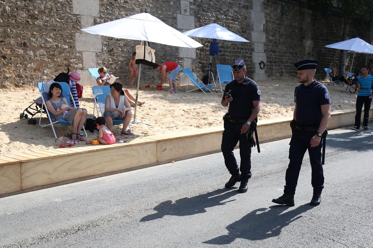 Policemen patrol during the opening day of the Paris Plages beach festival along the banks of River Seine in Paris.