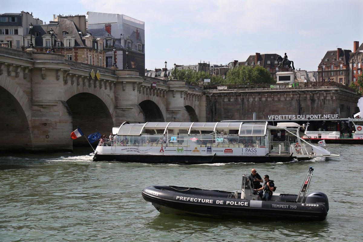 Policemen on a boat patrol along the banks of River Seine in Paris.