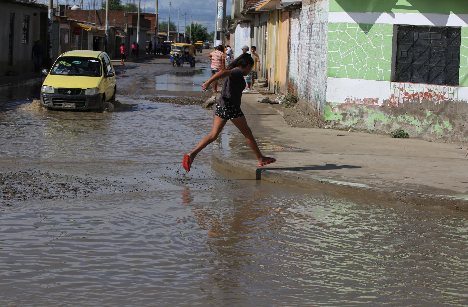 Woman crosses a flooded street in Piura, Peru.