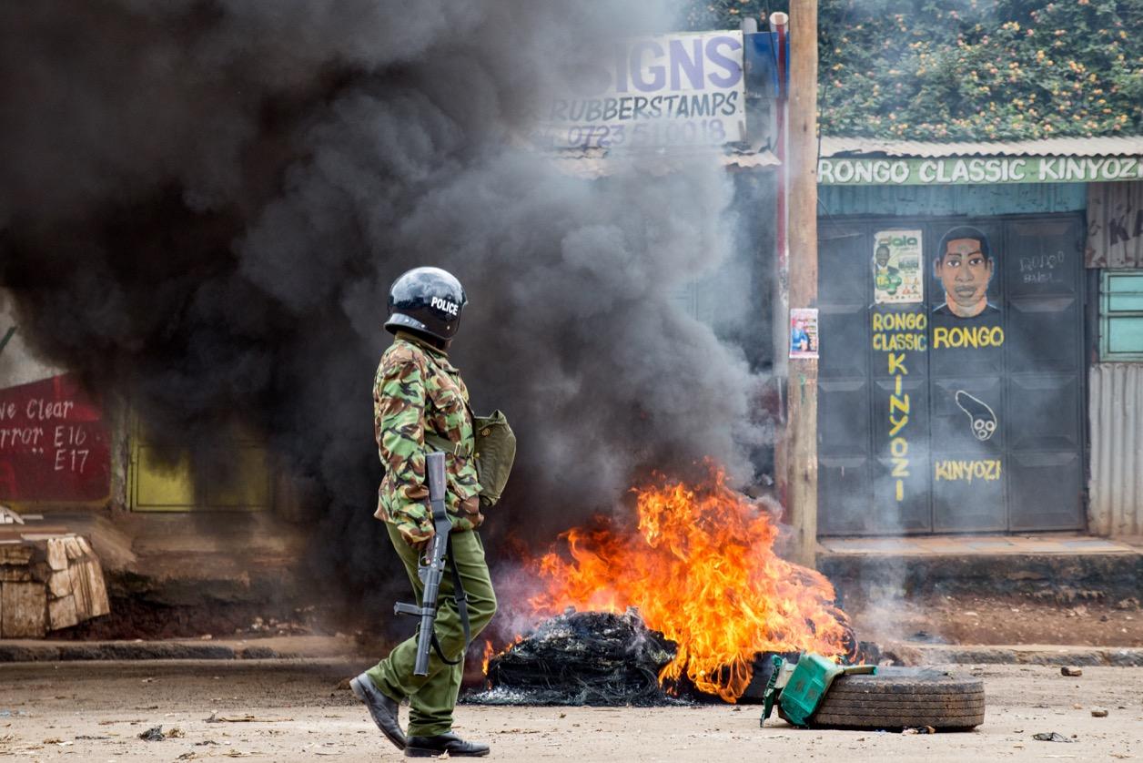 Police attempted to extinguish burning tires that blocked a main road in the Kibera slum.